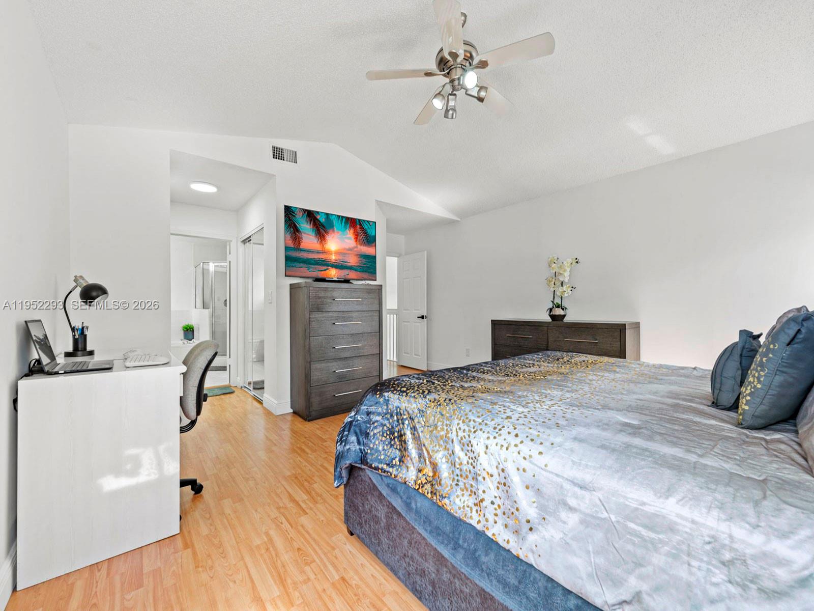 15626 Southwest 100th Terrace Miami, FL 33196 - Photo 20 of 30 a bedroom with a bed and a flat tv screen on dresser