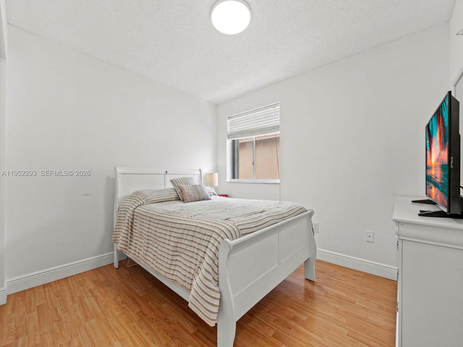 15626 Southwest 100th Terrace Miami, FL 33196 - Photo 25 of 30 a bedroom with a bed and a flat screen tv