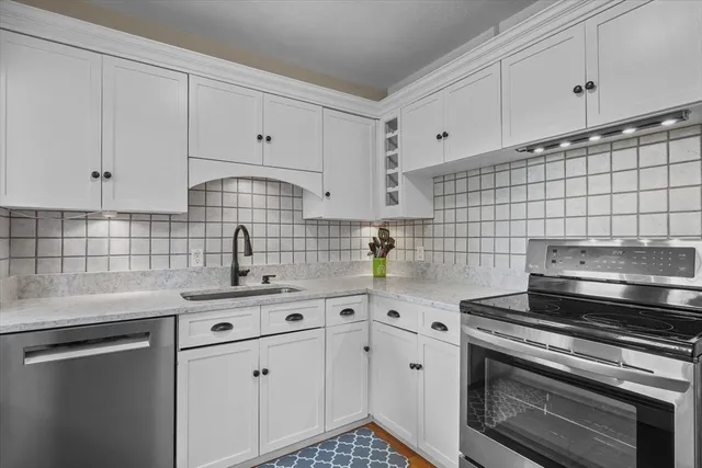 a kitchen with cabinets stainless steel appliances and sink