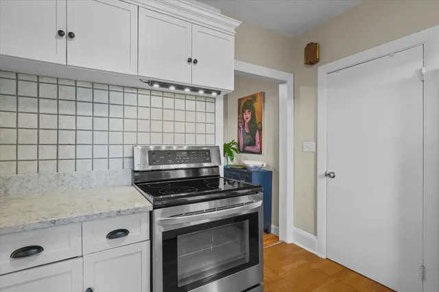 a kitchen with granite countertop white cabinets and white appliances