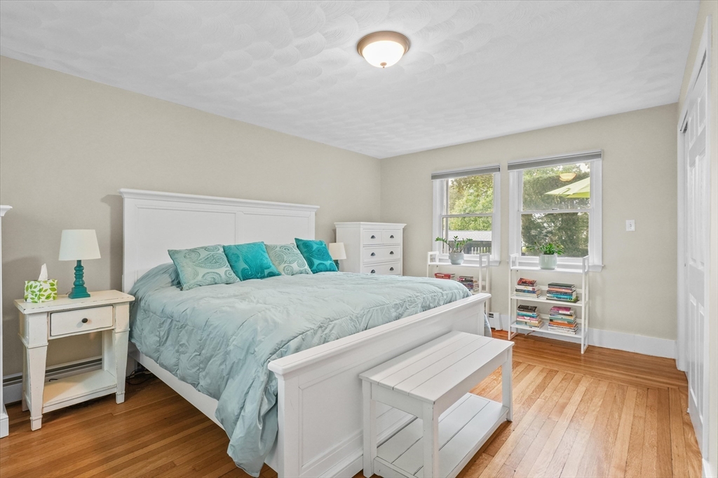 201 Humphrey Street, Unit 2 Marblehead, MA 01945 - Photo 20 of 31 a bedroom with a bed and a wooden floor
