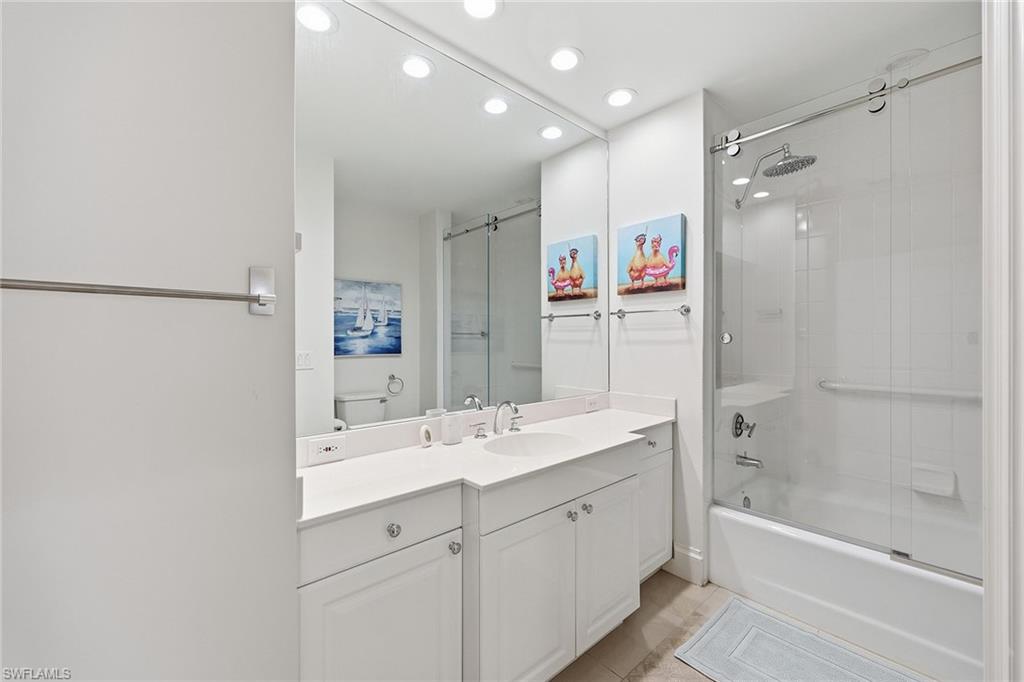 411 6th Street South, Unit 202 Naples, FL 34102 - Photo 27 of 37 a bathroom with a bathtub shower sink vanity and mirror