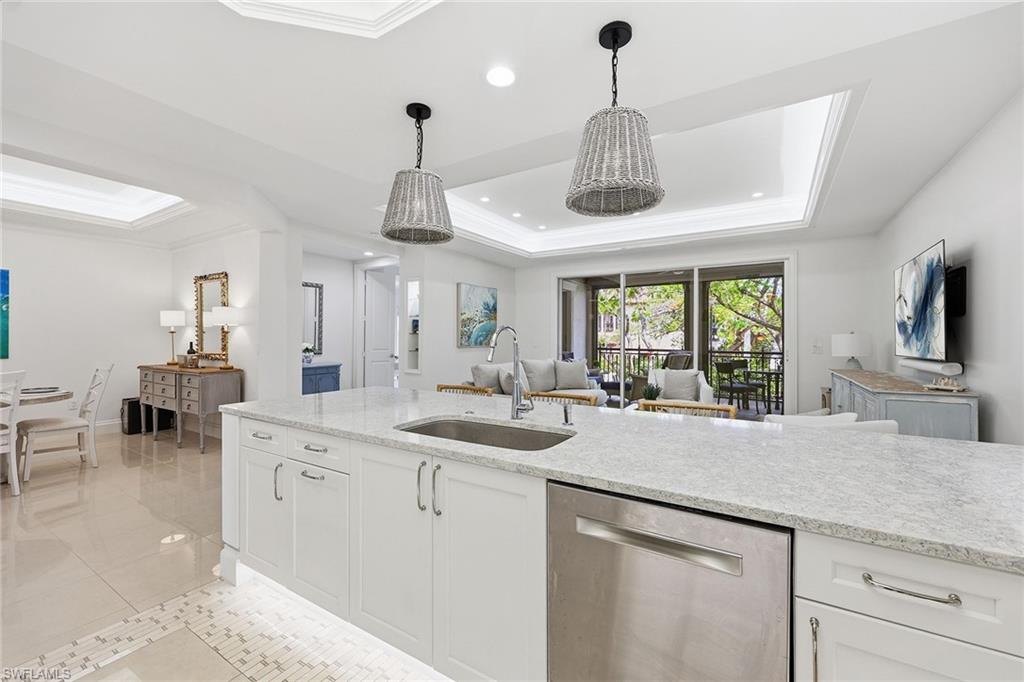 411 6th Street South, Unit 202 Naples, FL 34102 - Photo 10 of 37 a kitchen with center island a sink appliances and a chandelier