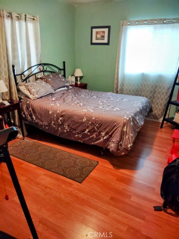 9778 Sharon Avenue Riverside, CA 92503 - Photo 6 of 19 a bedroom with a bed and wooden floor