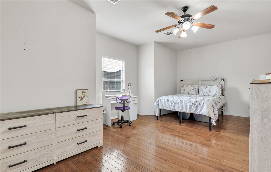 1425 West Villa Maria Road, Unit 1004 Bryan, TX 77801 - Photo 20 of 23 a bedroom with a bed and a chandelier
