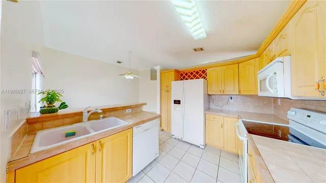 a kitchen with stainless steel appliances granite countertop a sink and a refrigerator