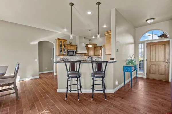 a kitchen with stainless steel appliances granite countertop a refrigerator a oven a stove and a wooden floors