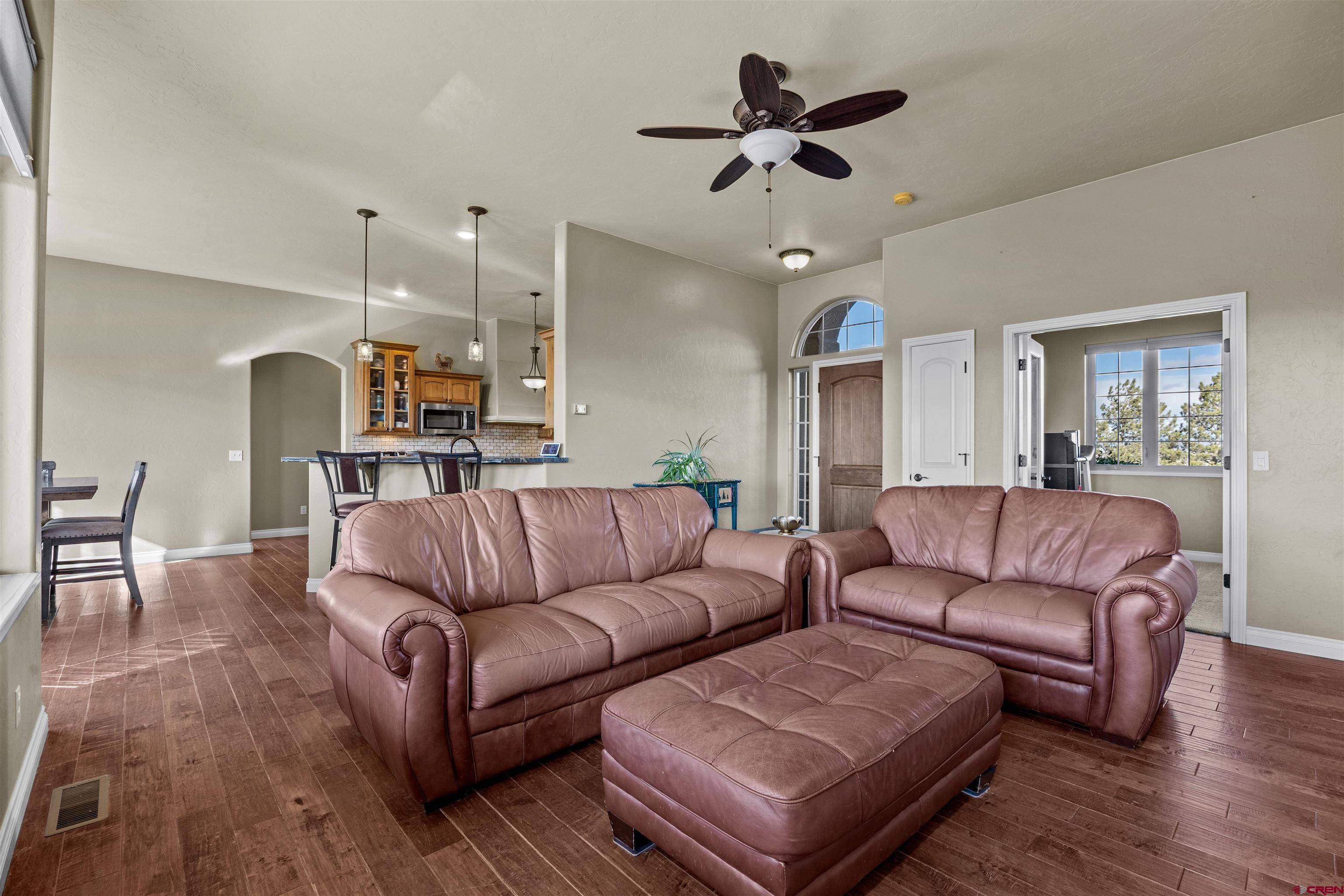 9838 5650th Road Olathe, CO 81425 - Photo 11 of 44 a living room with furniture kitchen view and a chandelier