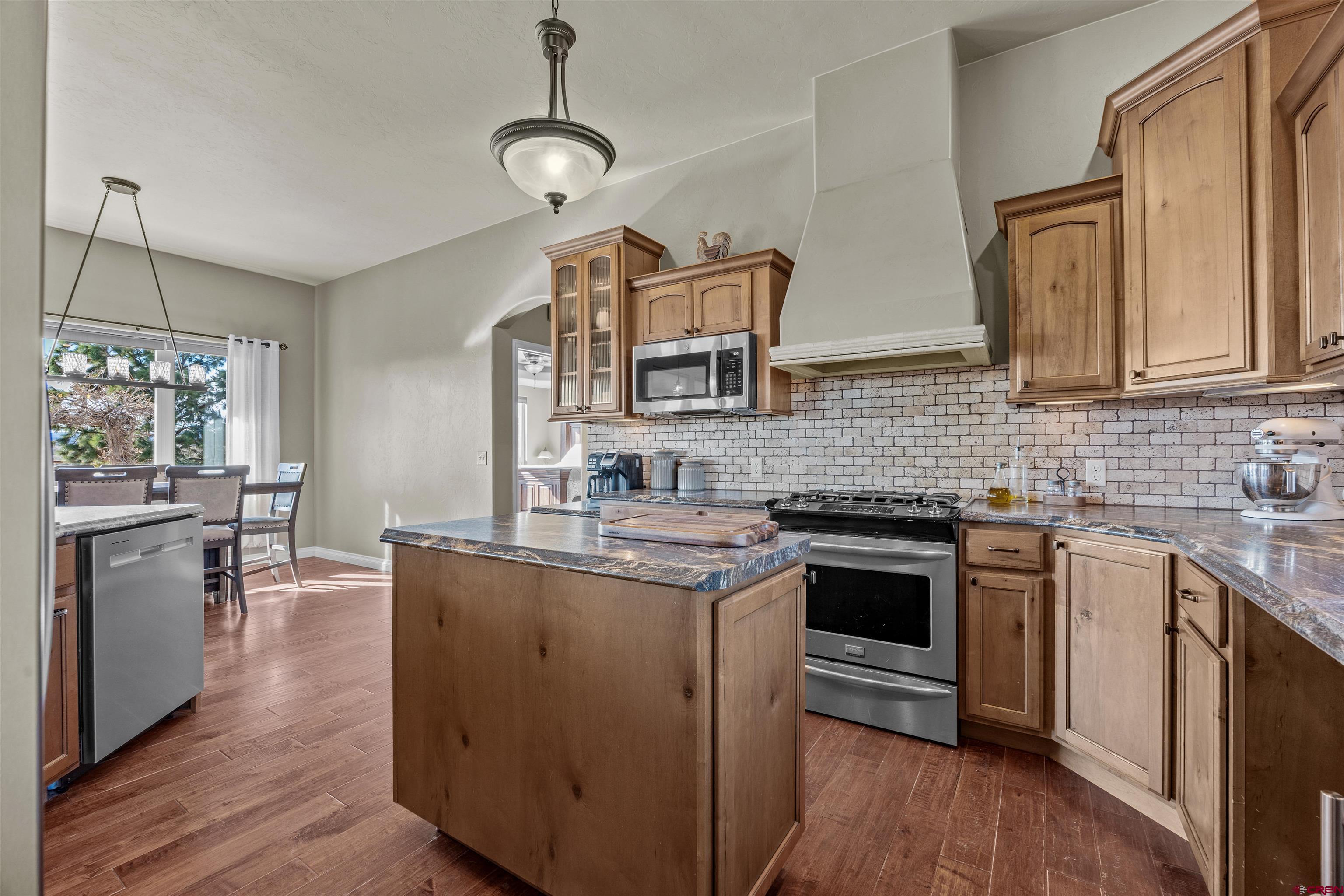 9838 5650th Road Olathe, CO 81425 - Photo 16 of 44 a kitchen with stainless steel appliances granite countertop a sink stove and refrigerator