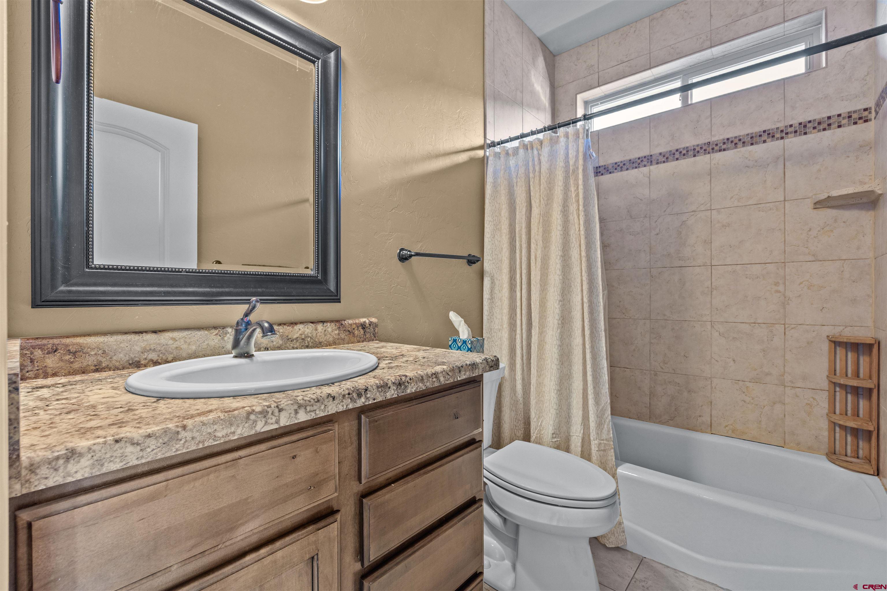 9838 5650th Road Olathe, CO 81425 - Photo 17 of 44 a bathroom with a granite countertop sink toilet and shower