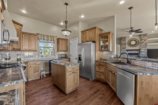 a kitchen with stainless steel appliances granite countertop a sink stove and cabinets