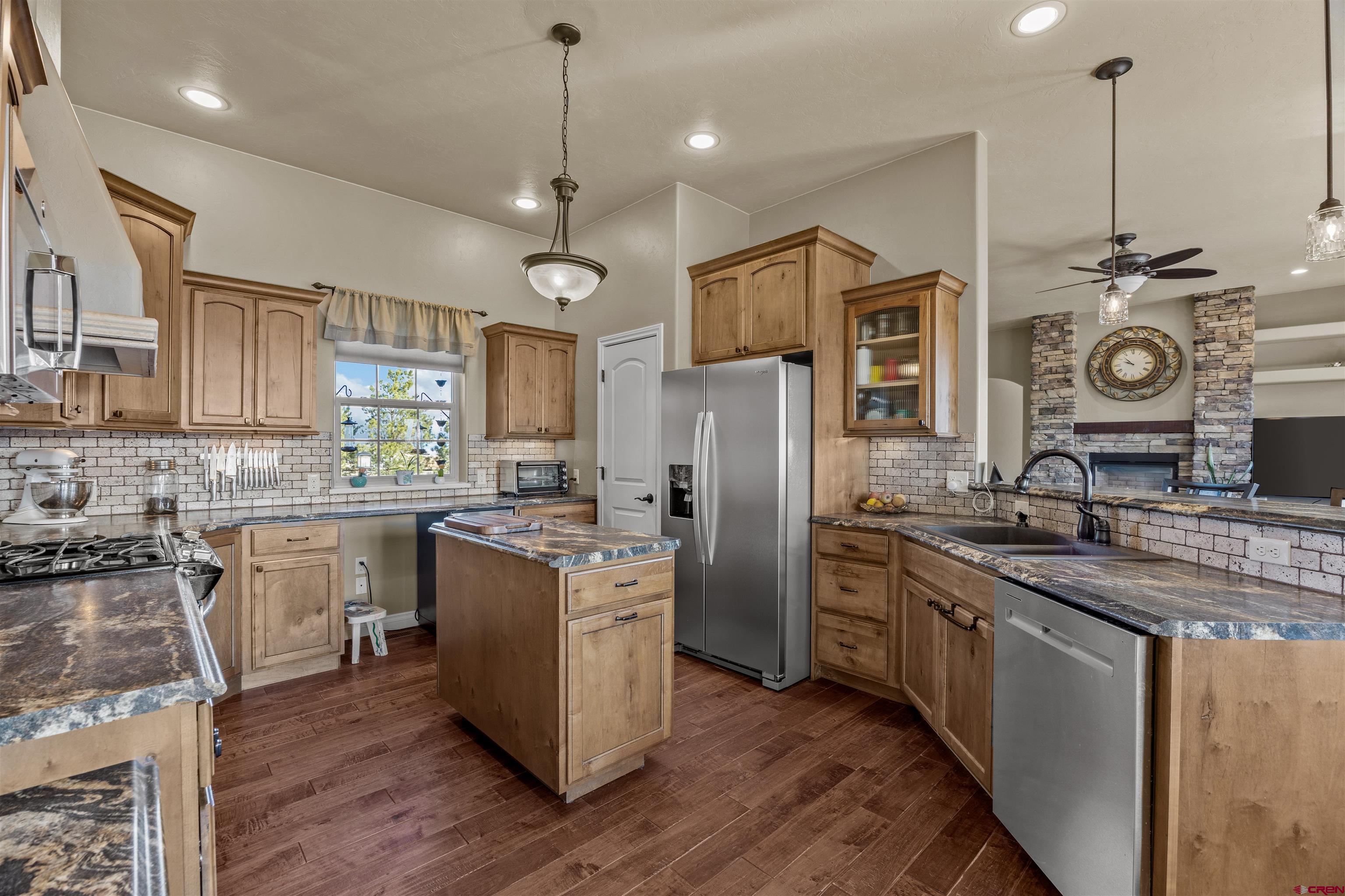 9838 5650th Road Olathe, CO 81425 - Photo 3 of 44 a kitchen with stainless steel appliances granite countertop a sink a stove a refrigerator and island with wooden floor