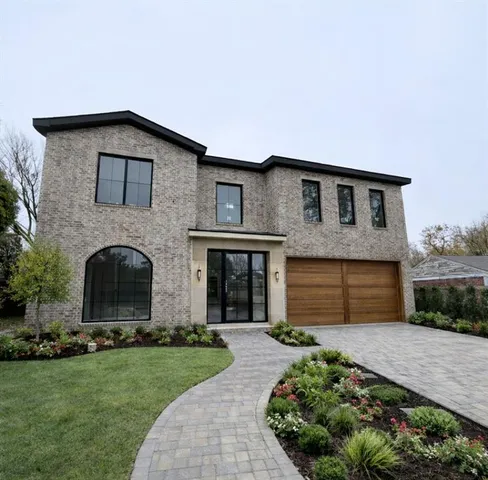 a front view of a house with a garden and plants