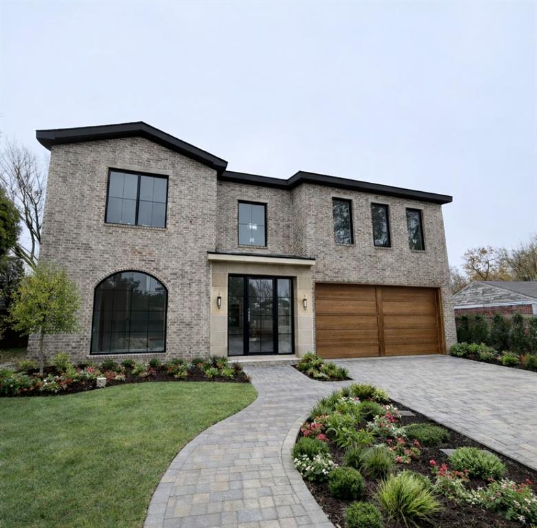 a front view of a house with a garden and plants