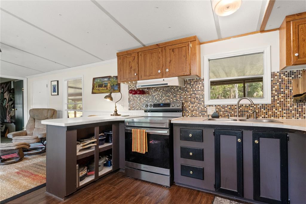 3650 176 Place Inglis, FL 34449 - Photo 19 of 49 a kitchen with stainless steel appliances granite countertop a stove and cabinets