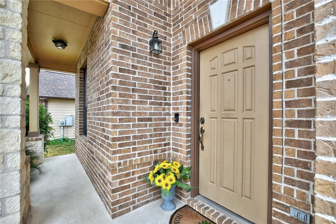 356 Matthews Kyle, TX 78640 - Photo 24 of 30 A welcoming entry features sturdy brick and stone construction, leading to a paneled front door.