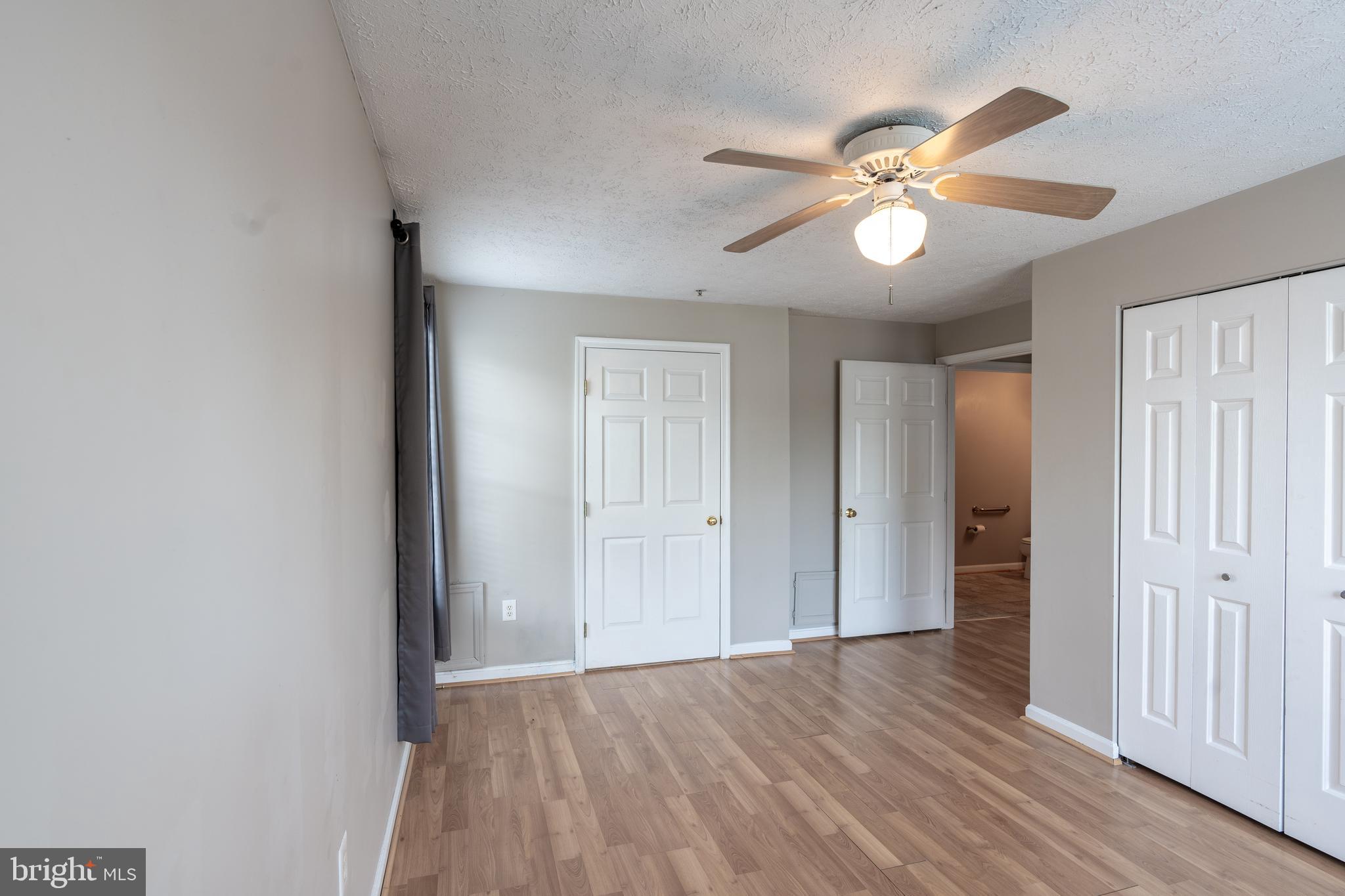 689 Winding Stream Way, Unit 101 Odenton, MD 21113 - Photo 11 of 23 wooden floor in an empty room with a window