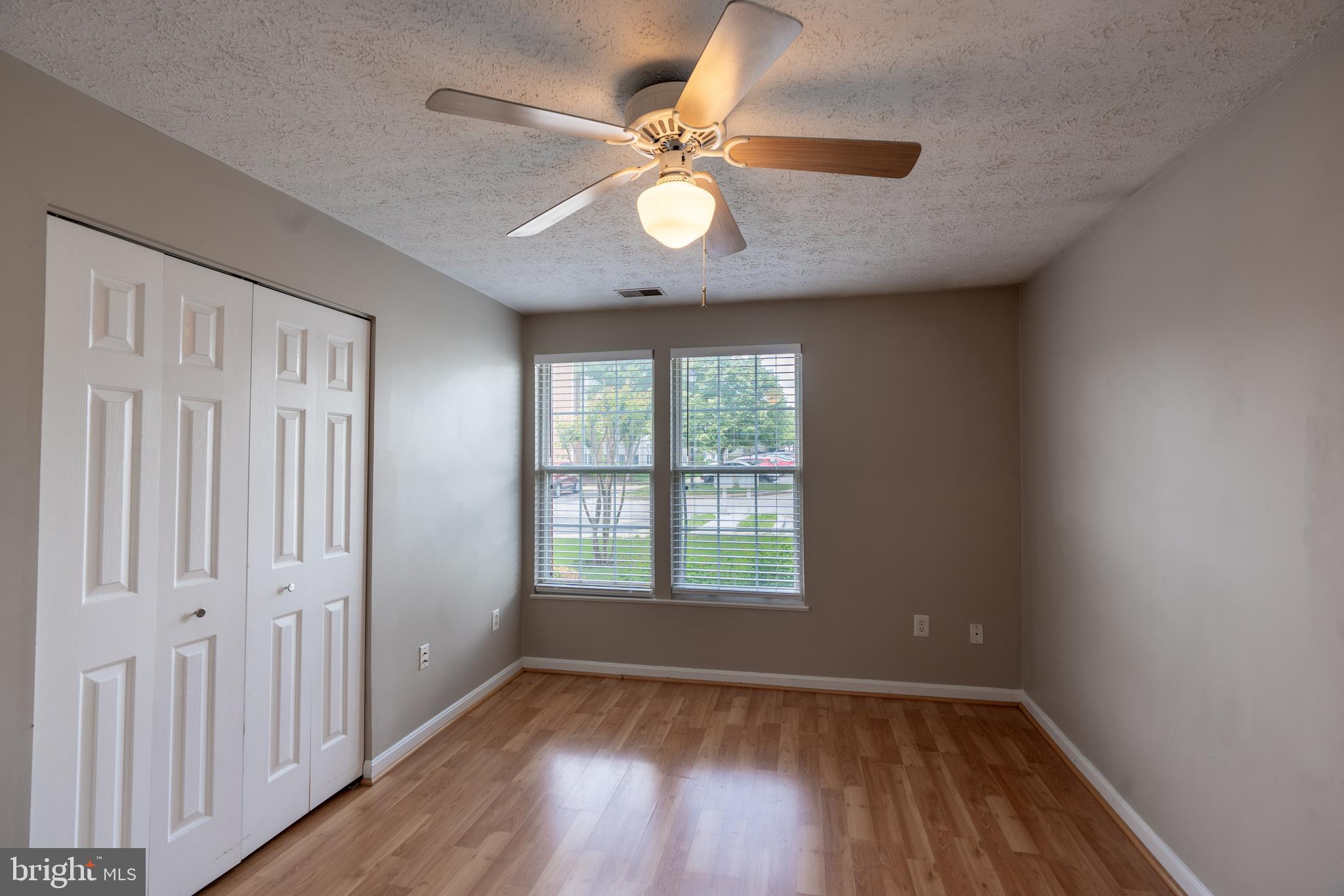 689 Winding Stream Way, Unit 101 Odenton, MD 21113 - Photo 12 of 23 wooden floor in an empty room with a window