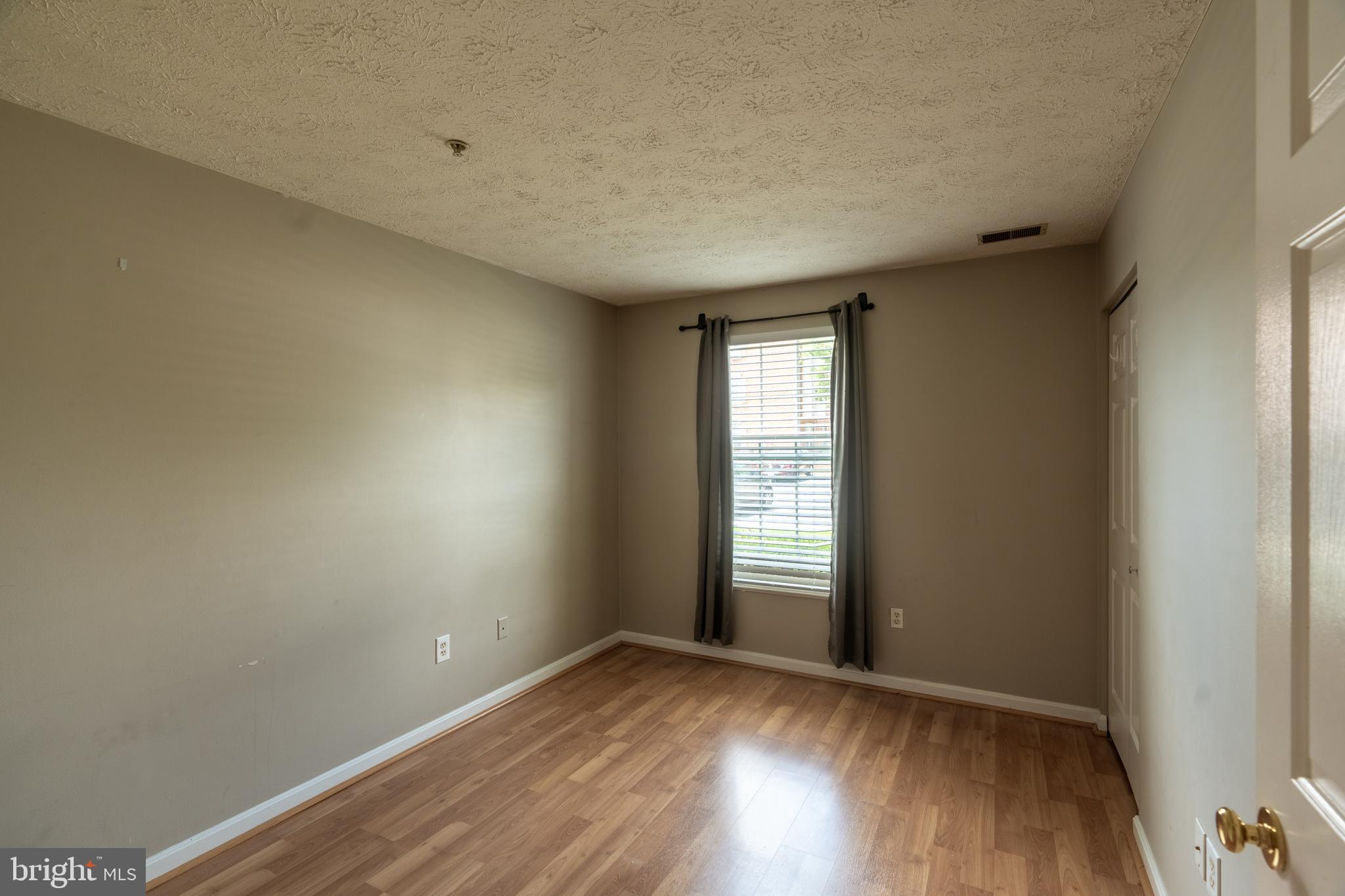689 Winding Stream Way, Unit 101 Odenton, MD 21113 - Photo 18 of 23 an empty room with wooden floor and windows