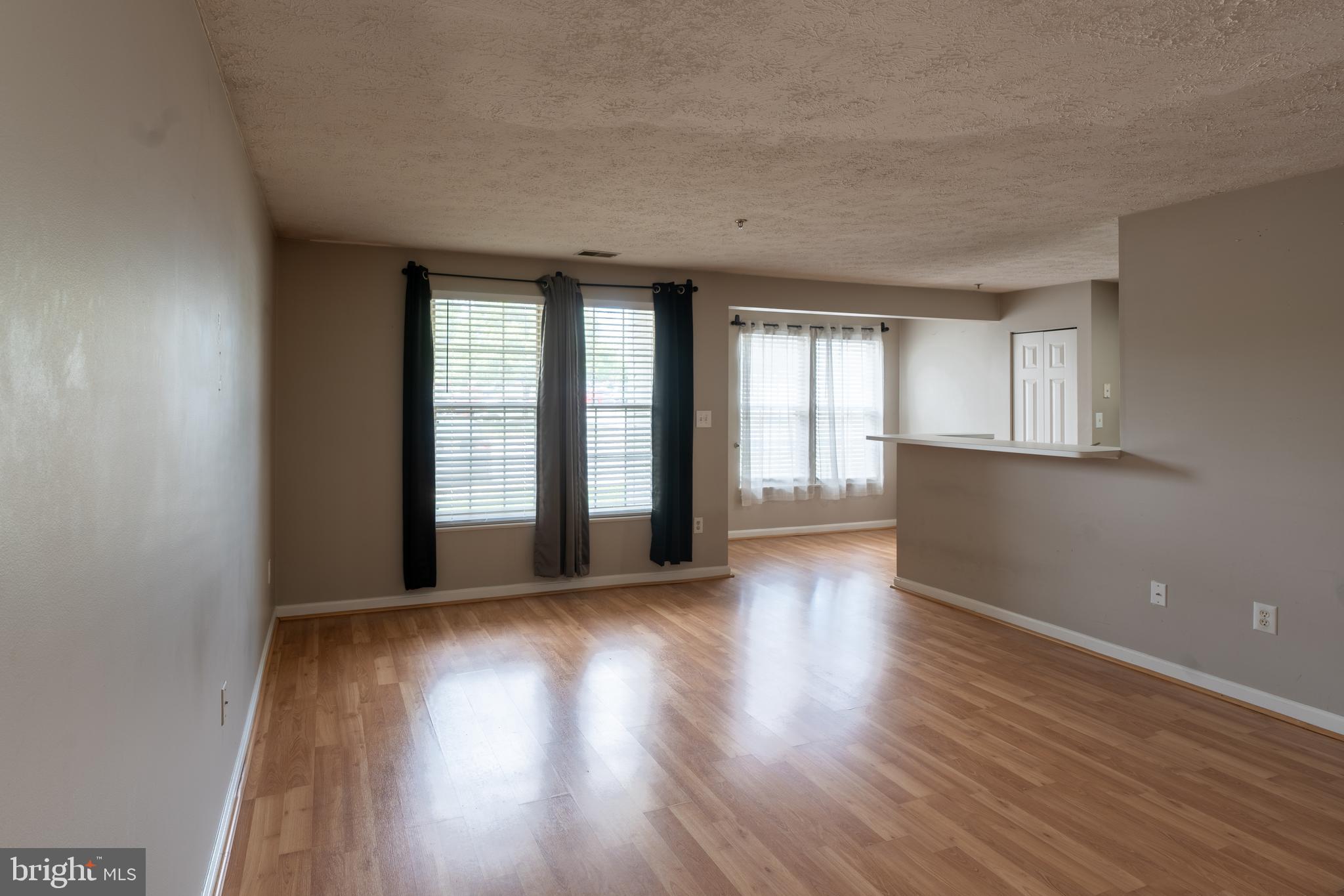 689 Winding Stream Way, Unit 101 Odenton, MD 21113 - Photo 4 of 23 a view of an empty room with wooden floor and a window