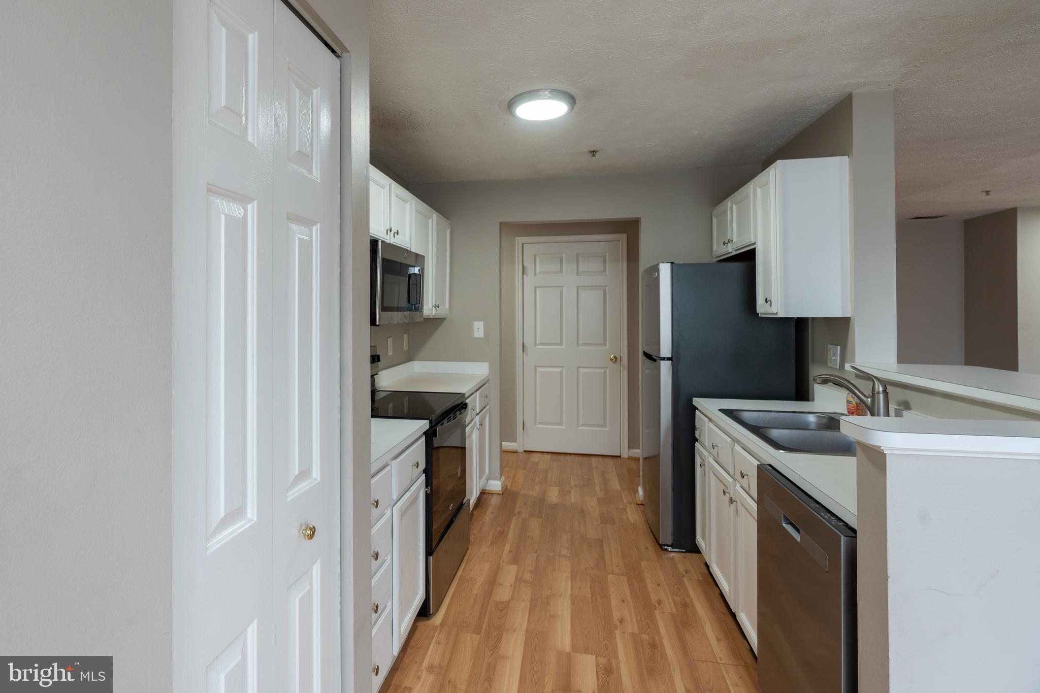 689 Winding Stream Way, Unit 101 Odenton, MD 21113 - Photo 5 of 23 a kitchen with a sink stove and refrigerator