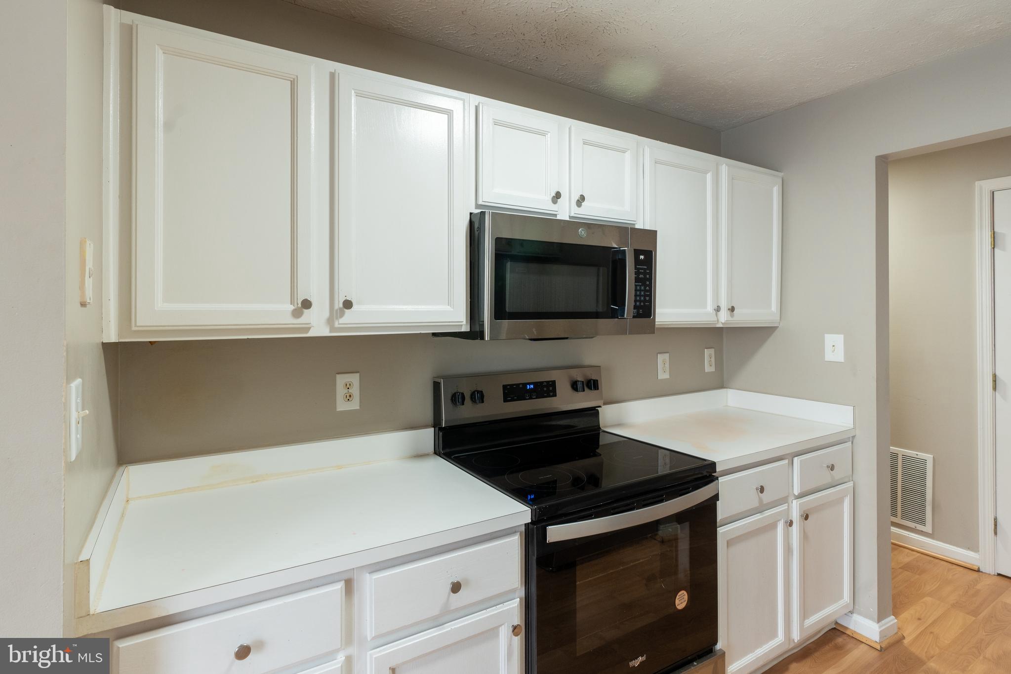 689 Winding Stream Way, Unit 101 Odenton, MD 21113 - Photo 6 of 23 a kitchen with white cabinets and stainless steel appliances