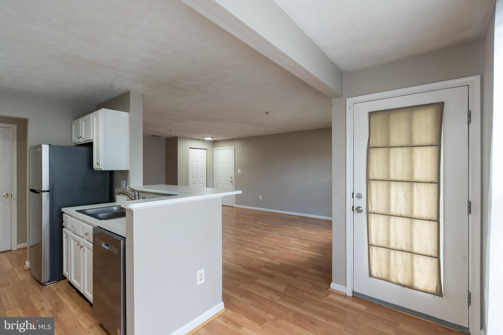 689 Winding Stream Way, Unit 101 Odenton, MD 21113 - Photo 7 of 23 a room with refrigerator and wooden floor