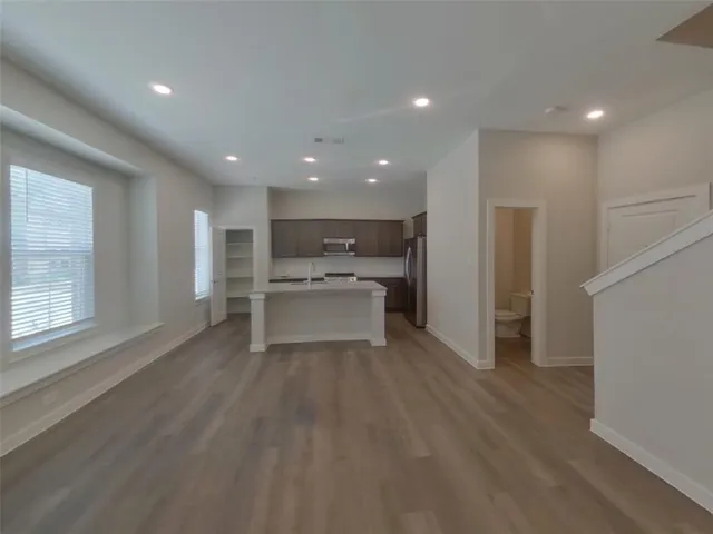 a view of a kitchen with wooden floor and windows