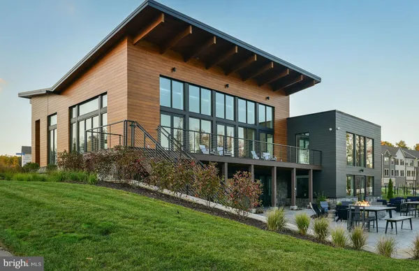 a front view of a building with glass windows and lake view