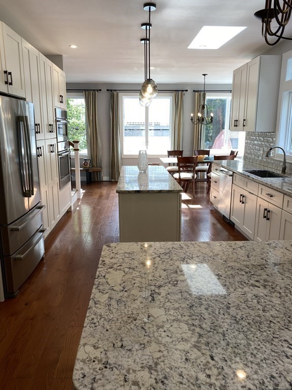 9 York Road Newton, MA 02468 - Photo 7 of 41 a large kitchen with kitchen island granite countertop a large counter top appliances a sink and a chandelier