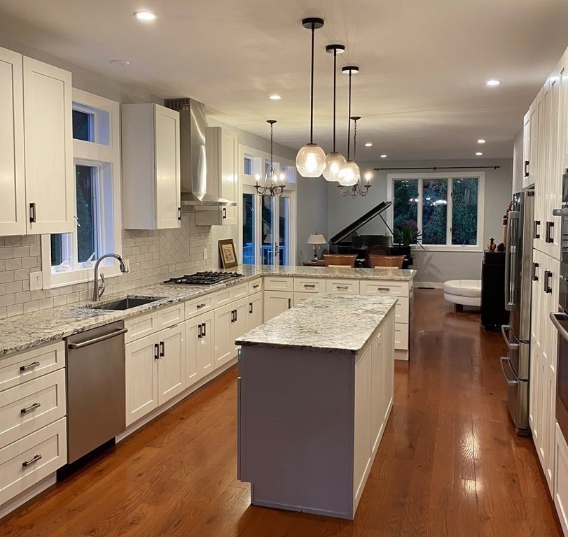 9 York Road Newton, MA 02468 - Photo 8 of 41 a large kitchen with kitchen island a sink a stove and a large refrigerator with wooden floor