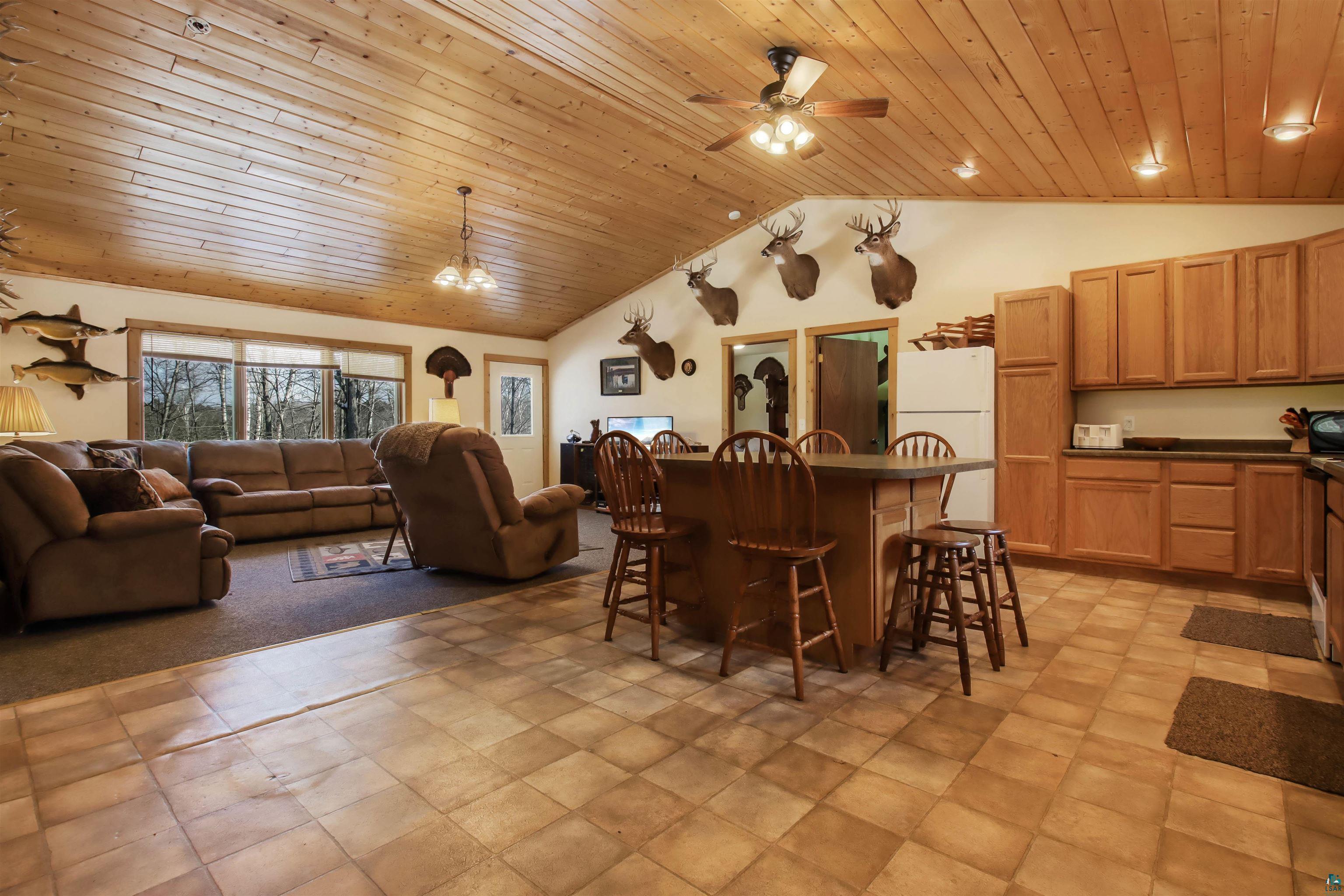 16525 Sand Hill Road Mason, WI 54856 - Photo 38 of 38 Kitchen featuring open floor plan, a kitchen bar, wooden ceiling, dark countertops, and freestanding refrigerator