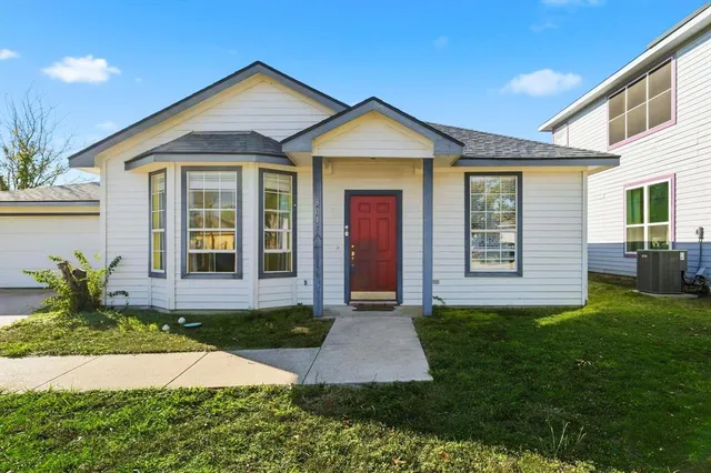 a front view of a house with a yard and potted plants