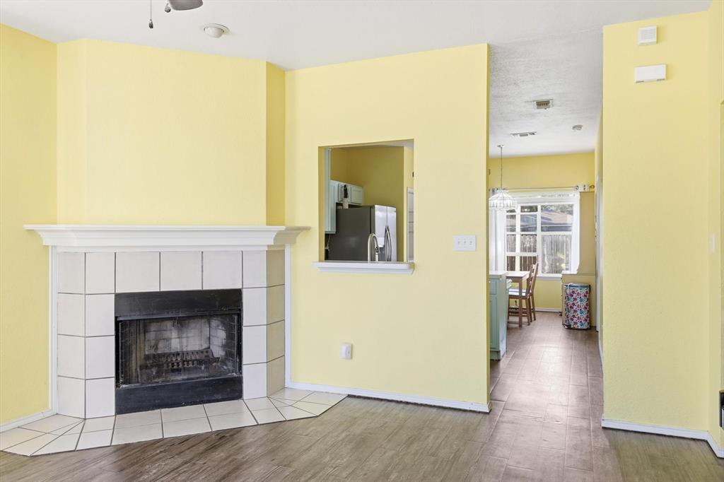 801 Indigo Terrace Denton, TX 76209 - Photo 11 of 40 a living room with a fireplace and a wooden floor