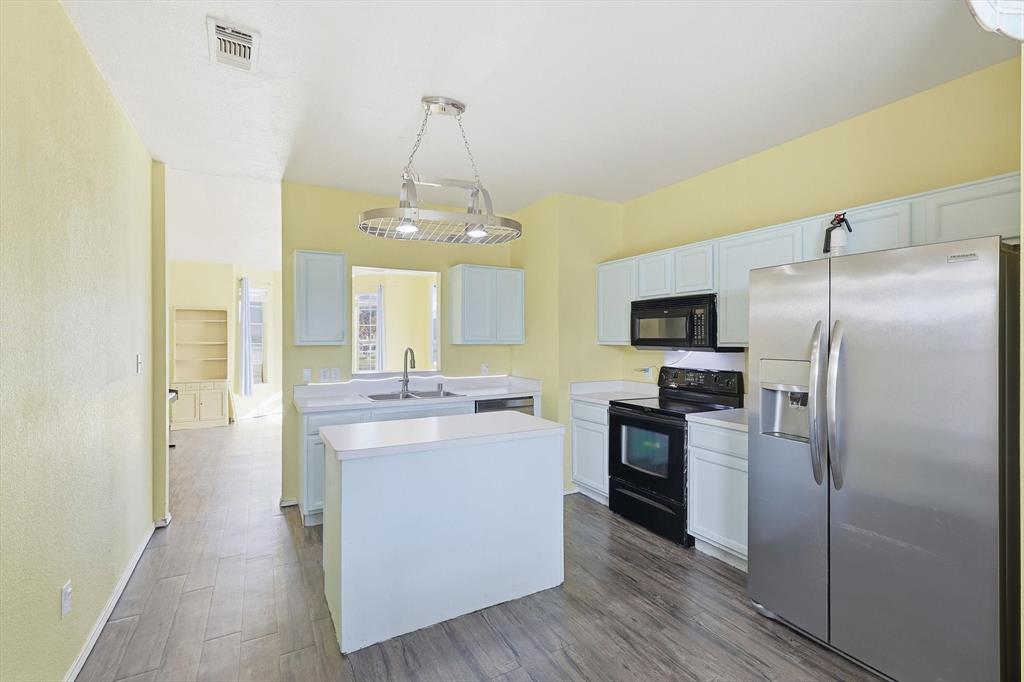 801 Indigo Terrace Denton, TX 76209 - Photo 14 of 40 a kitchen with stainless steel appliances a refrigerator sink and stove