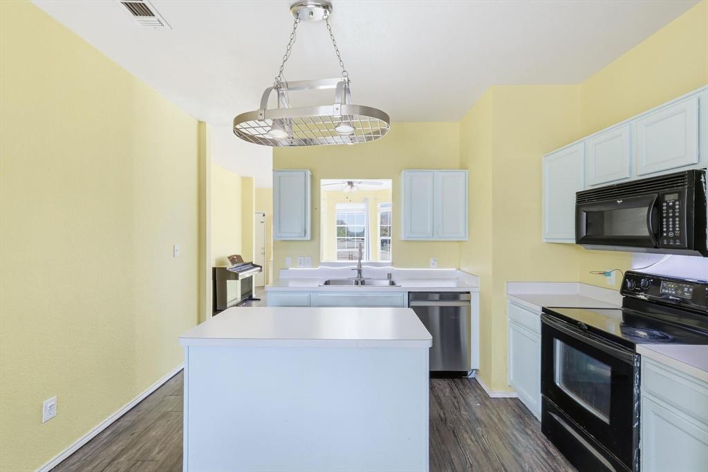 801 Indigo Terrace Denton, TX 76209 - Photo 15 of 40 a kitchen with a sink stainless steel appliances and a chandelier