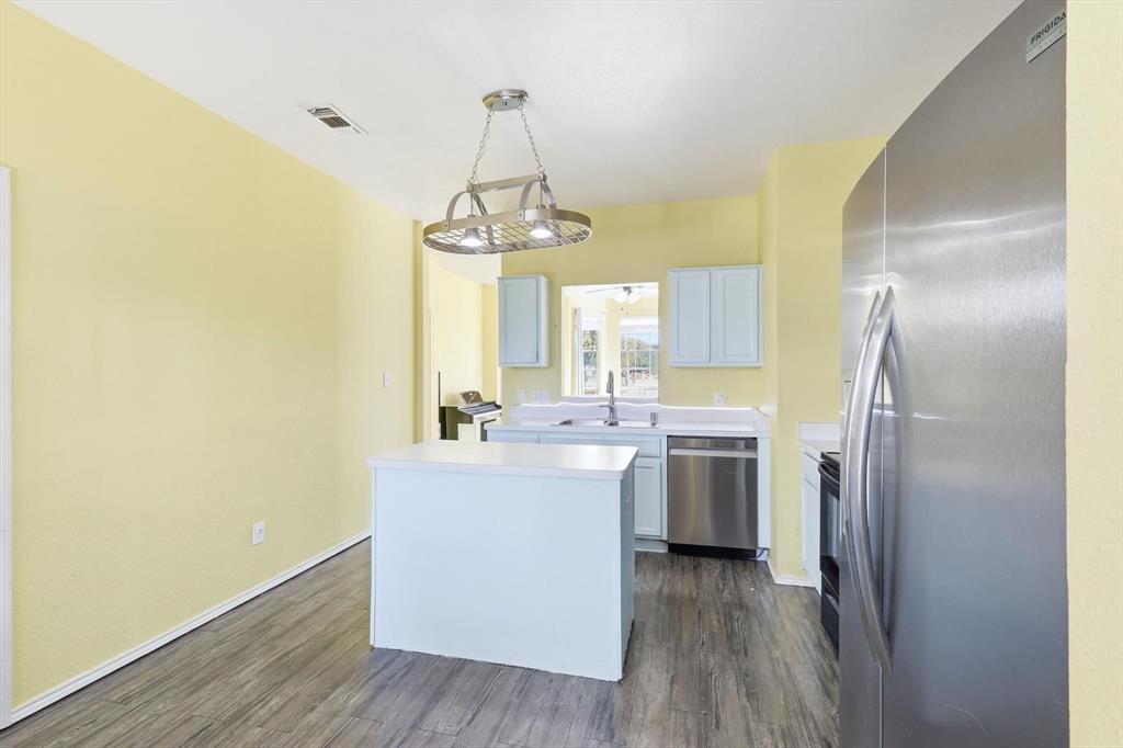 801 Indigo Terrace Denton, TX 76209 - Photo 16 of 40 a view of a kitchen with a sink and dishwasher a refrigerator with wooden floor