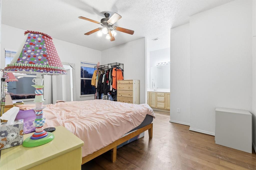 801 Indigo Terrace Denton, TX 76209 - Photo 23 of 40 a bedroom with a bed and a chandelier