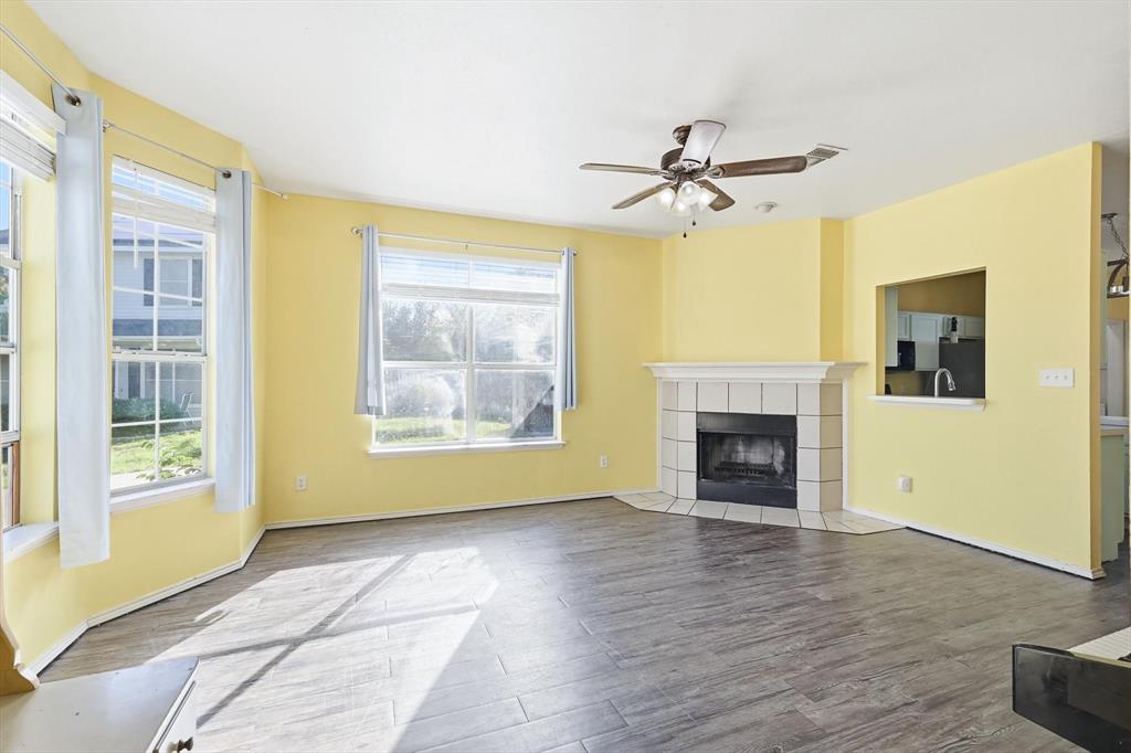801 Indigo Terrace Denton, TX 76209 - Photo 5 of 40 a view of a livingroom with a fireplace a ceiling fan and wooden floor