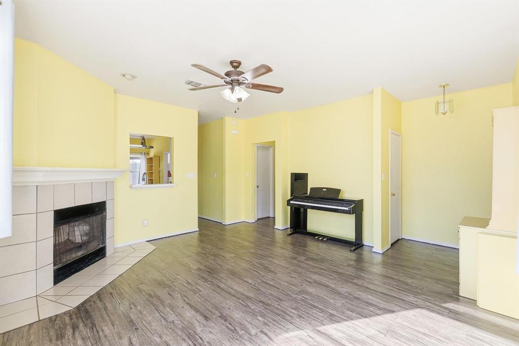 801 Indigo Terrace Denton, TX 76209 - Photo 6 of 40 a view of an empty room with a fireplace and a window