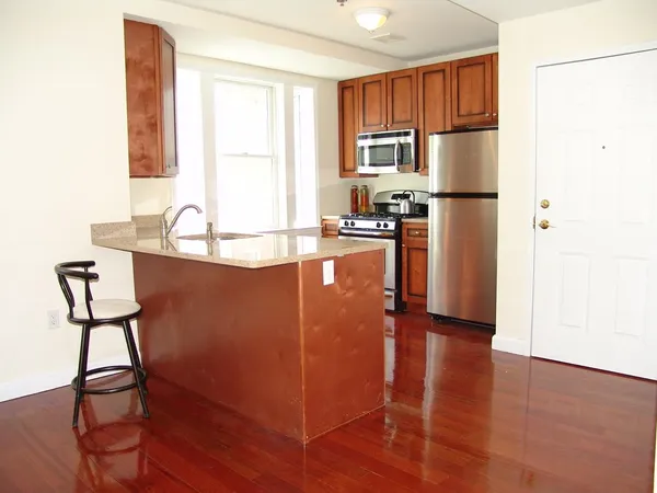a kitchen with granite countertop a refrigerator stove and sink