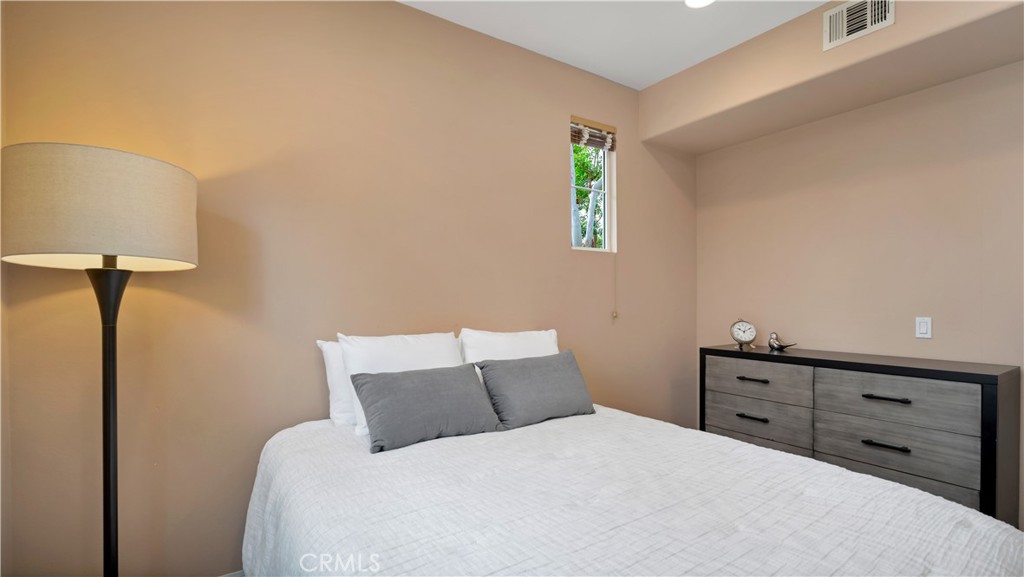 47 Nightshade Irvine, CA 92603 - Photo 16 of 56 a bedroom with a bed and a lamp on dresser