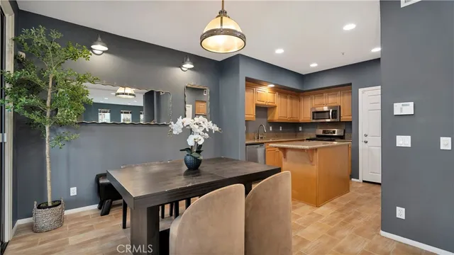 a kitchen with sink refrigerator dining table and chairs