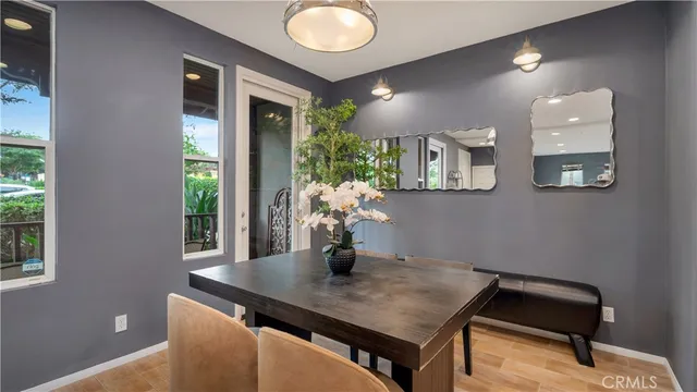 a living room with stainless steel appliances granite countertop furniture wooden floor and a large window