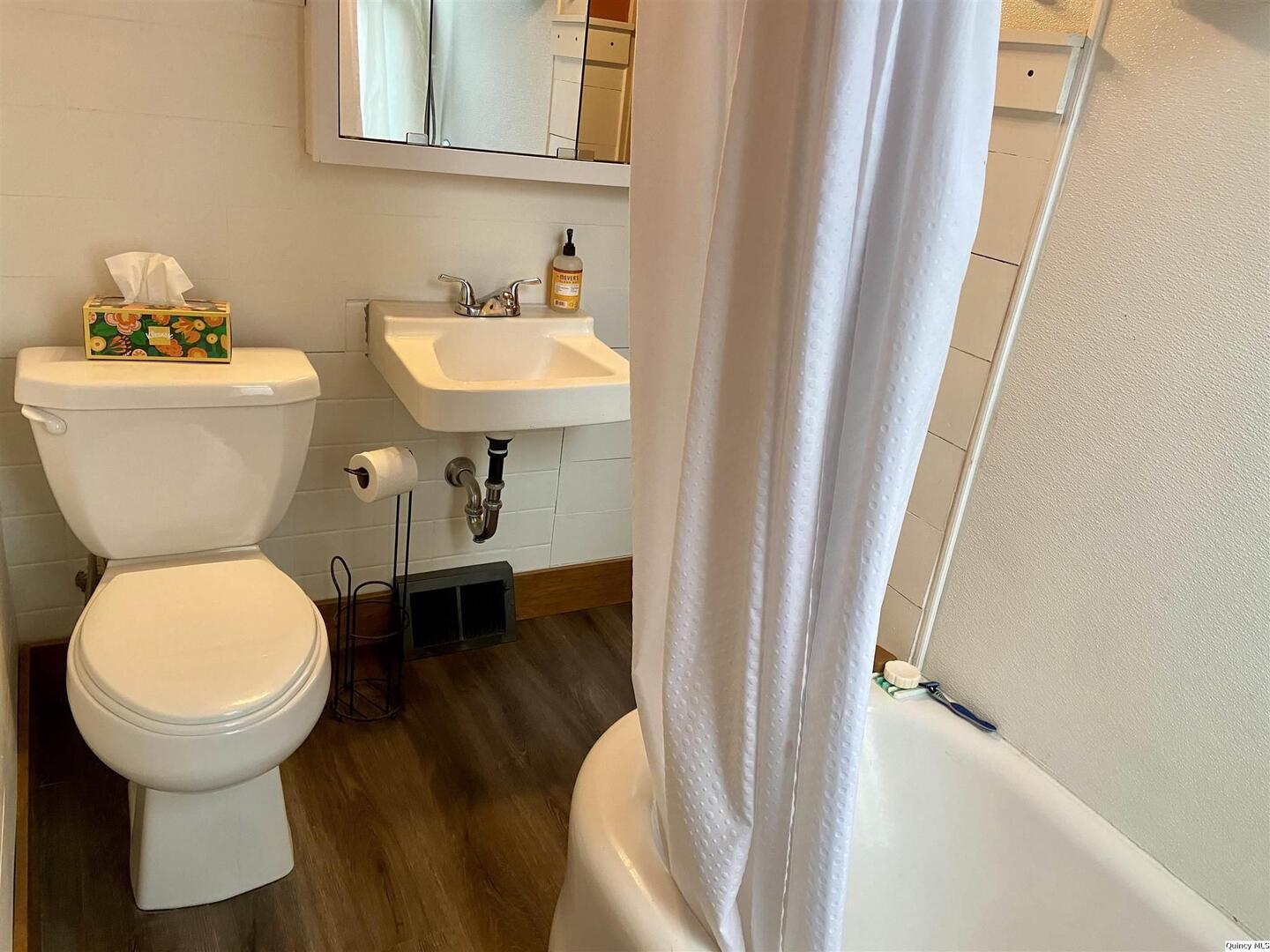 614 South 22nd Street Quincy, IL 62301 - Photo 15 of 27 a bathroom with a toilet sink and mirror