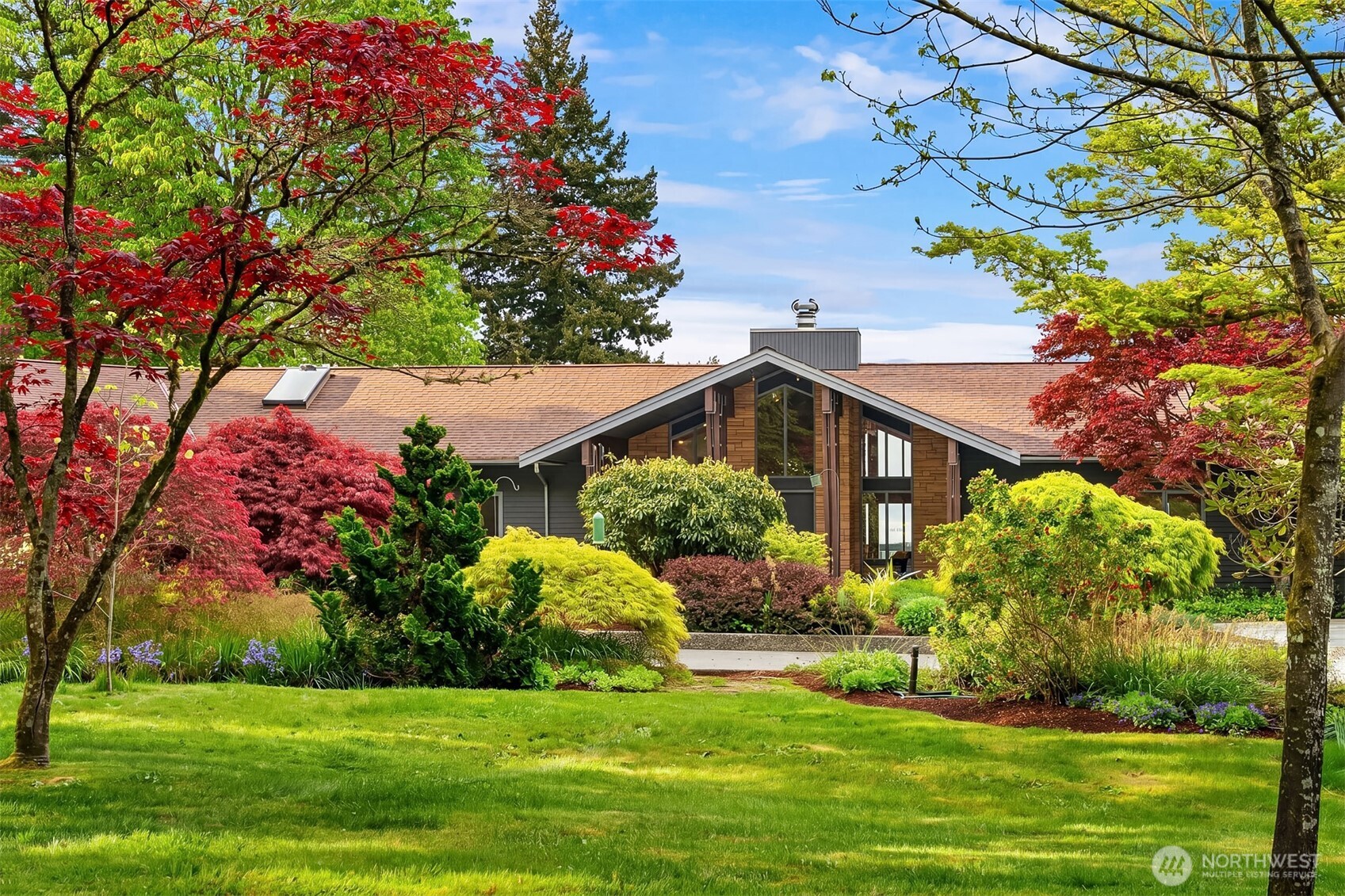 a front view of a house with a yard and potted plants
