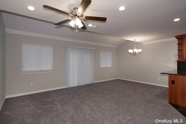 an empty room with a chandelier fan and windows