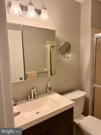 a bathroom with a sink vanity mirror and toilet