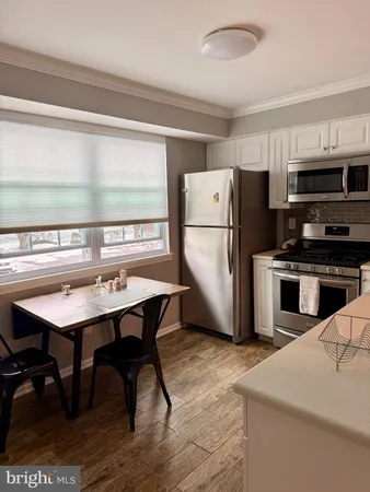 a kitchen with refrigerator cabinets and wooden floor