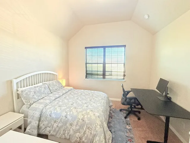 a bed sitting in a bedroom next to a window